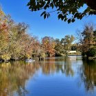 Tranquil autumn garden with colorful trees and still pond