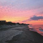 Scenic sunset with pink and orange hues over beach pier