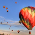 Colorful hot air balloons in blue sky with fluffy clouds