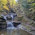 Vibrant waterfall scene with orange and red autumn foliage