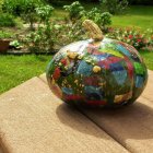 Colorful Ornate Pumpkin with Gold Patterns and Gem Accents in Sunlit Setting