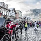 Snowy Winter Village Scene with Festive Decorations and Horse-Drawn Carriage