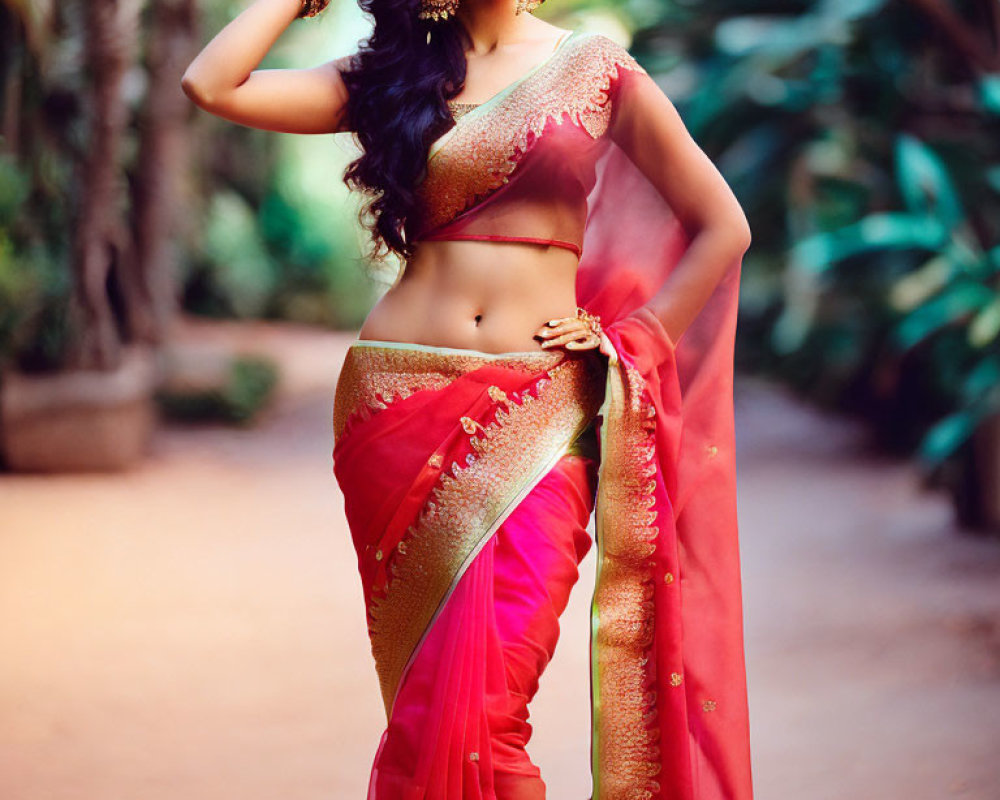 Traditional Indian Woman in Red and Gold Sari Poses in Garden