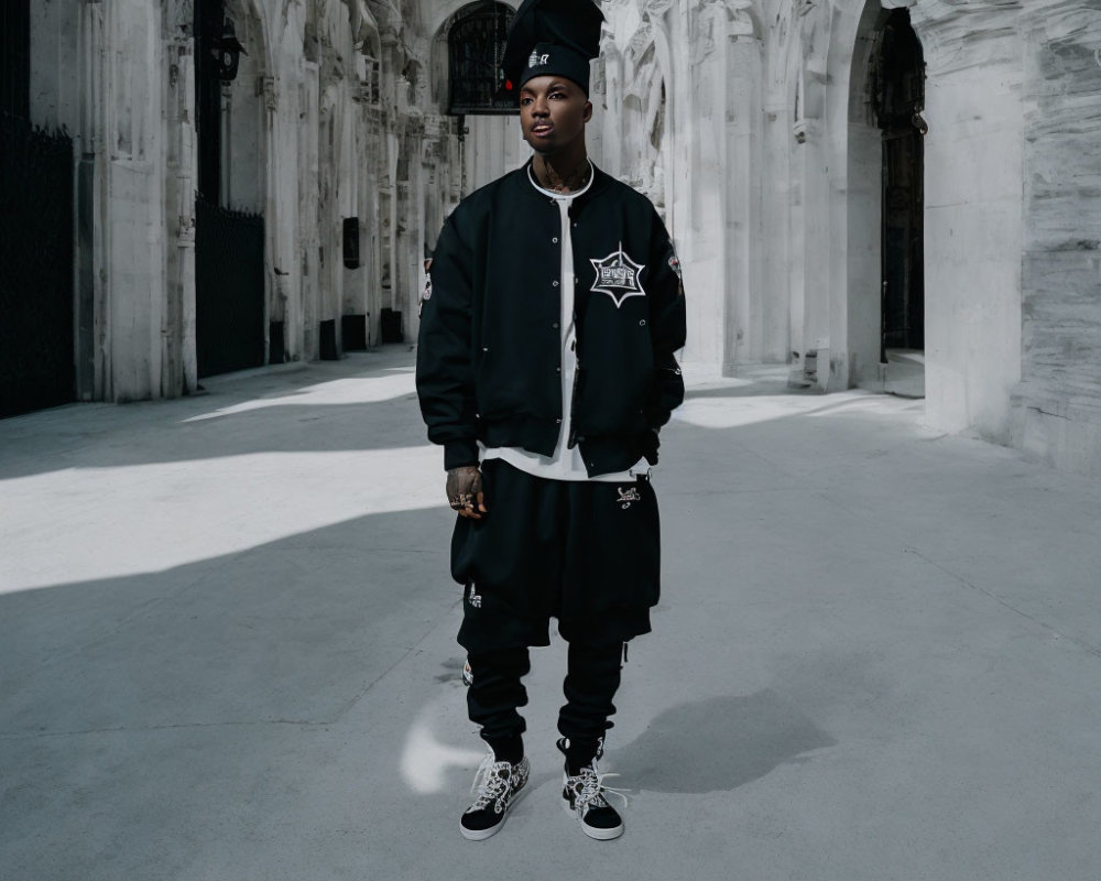 Stylish person in streetwear in symmetrical white stone arcade