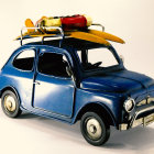 Vintage Blue Car with Surfboard and Kayak on Roof Rack