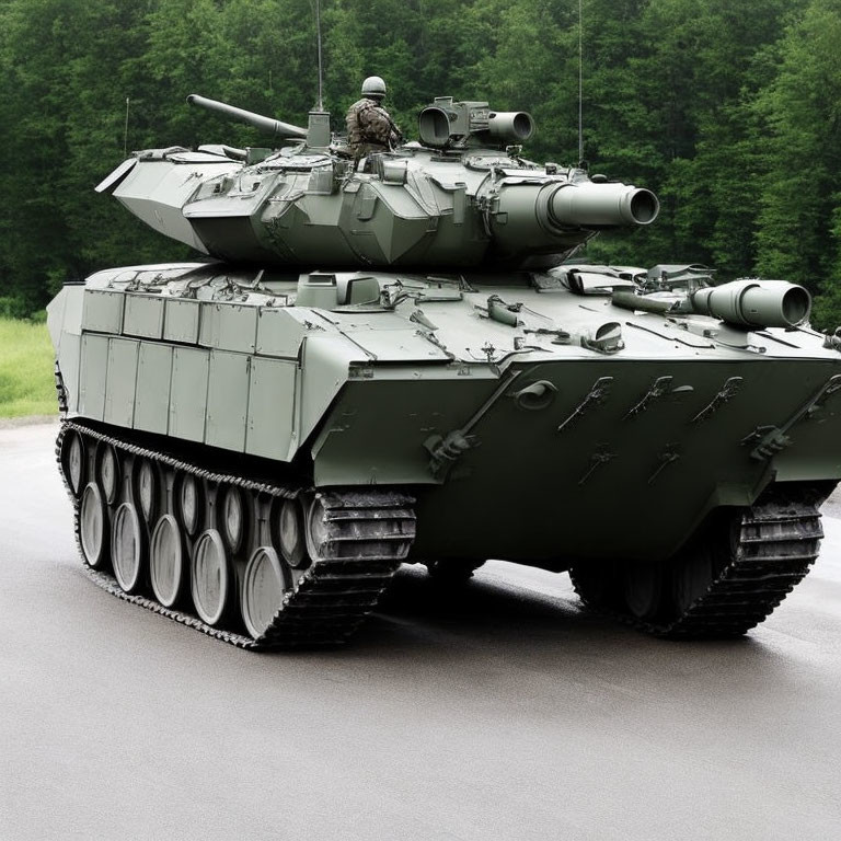 Camouflaged soldier on modern battle tank against green trees