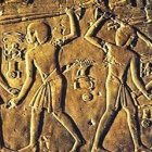 Ancient Egyptian hieroglyphs and bas-relief carving of traditional figures in ritual.