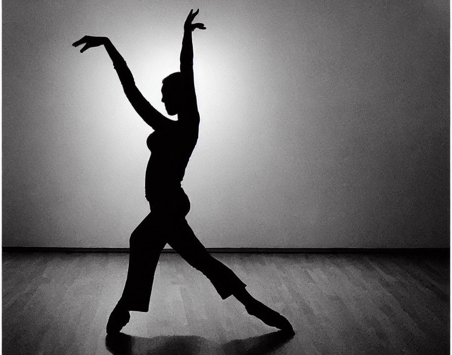 Expressive dancer silhouette against bright background on wooden floor