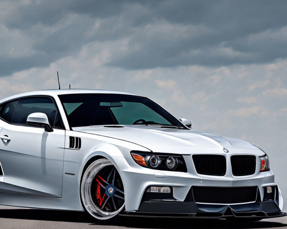 Custom White BMW with Red Detailed Rims and Cloudy Sky