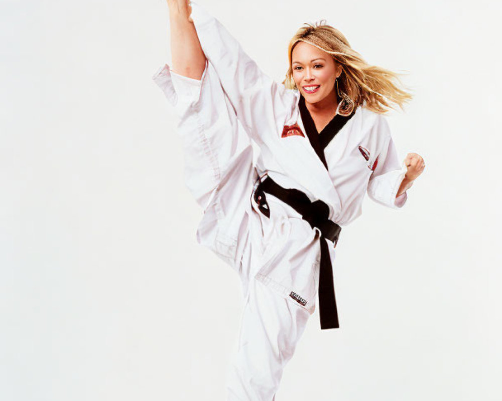 Martial artist in white taekwondo uniform with black belt executing high kick