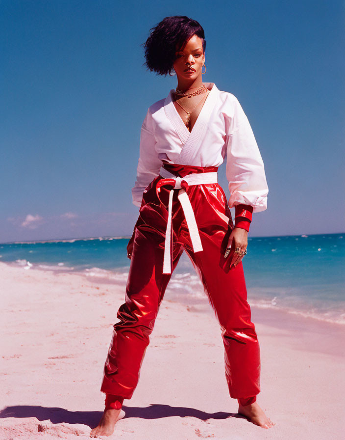 Person on Beach in White Top and Red Satin Pants with Gold Jewelry