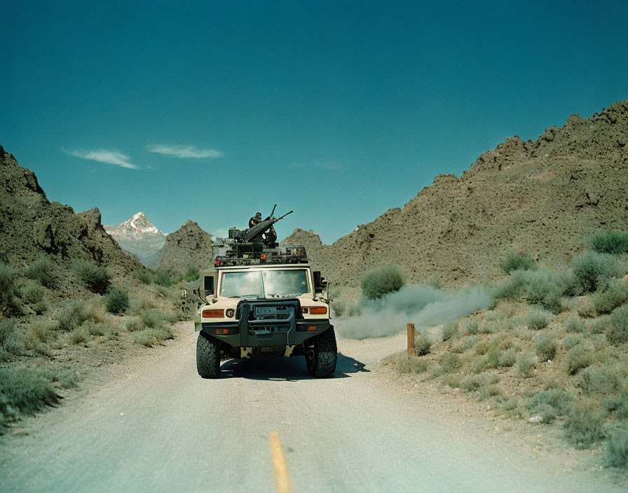 Armed military Humvee on desert road with mounted gun