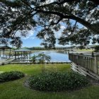 Tranquil lakeside house with garden, tree branch, dock, rowboat