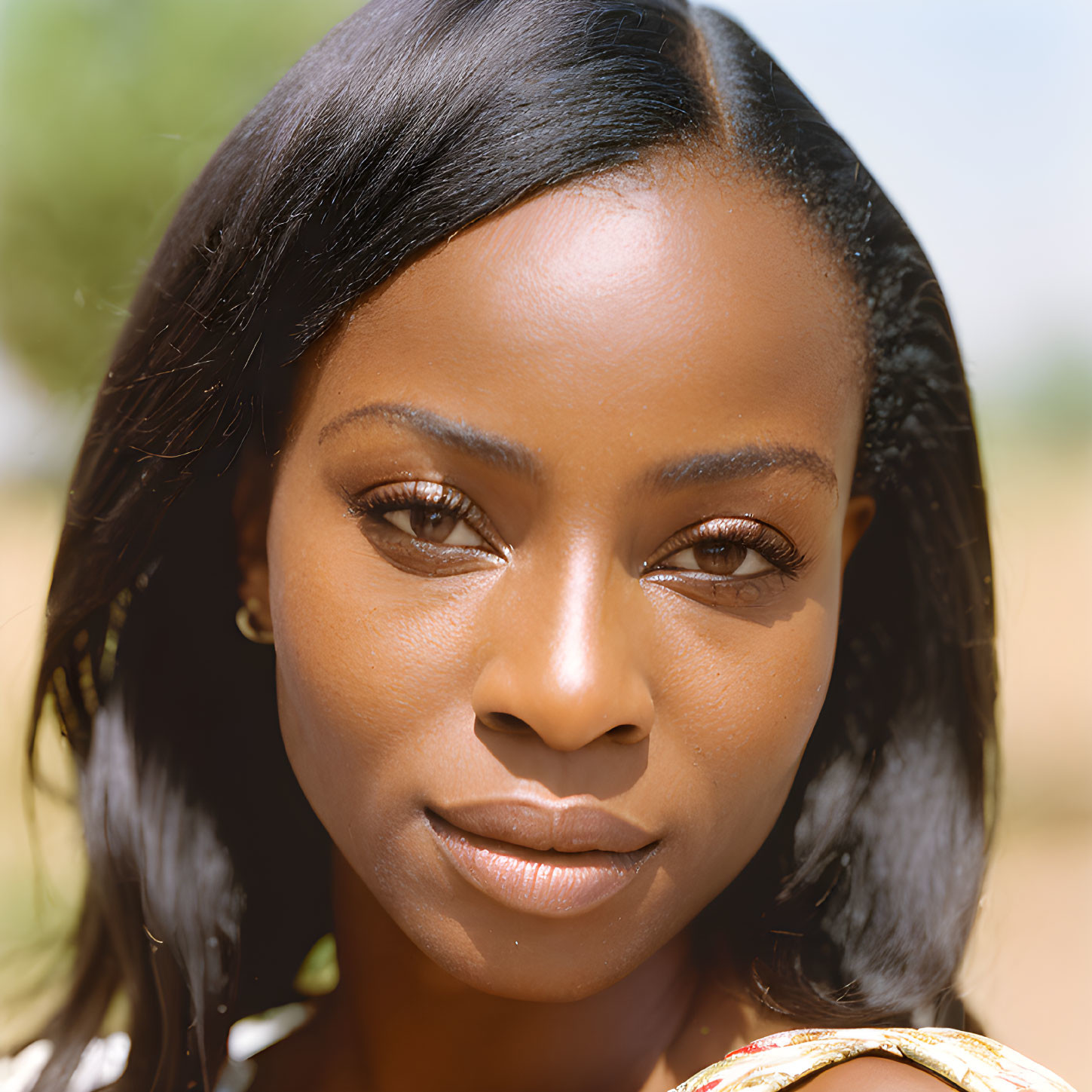 Portrait of woman with clear skin and dark hair against blurred background