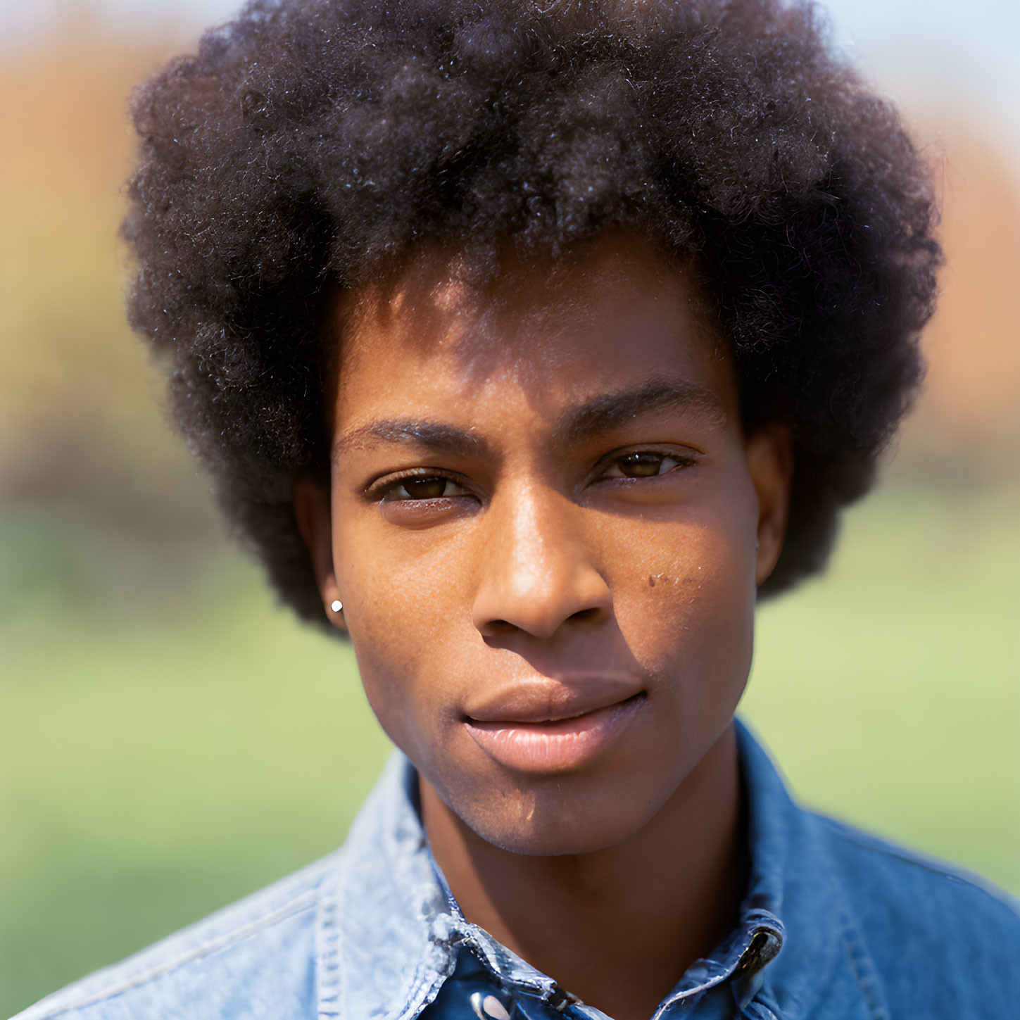 Person with Afro in Denim Shirt Outdoors - Close-up Shot