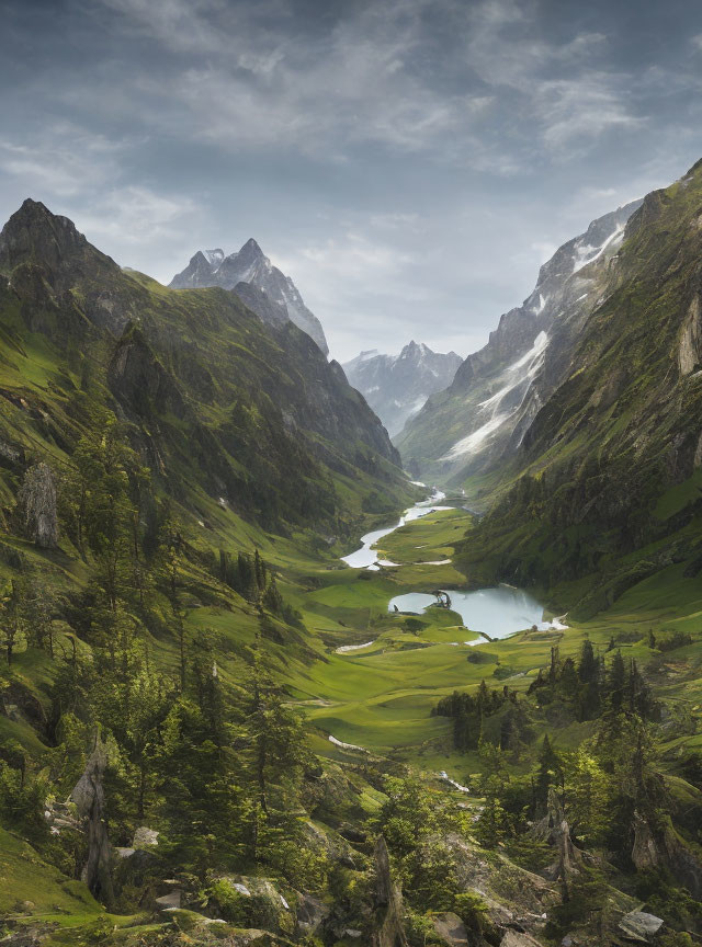 Serene mountain valley with lush meadows, river, and towering peaks