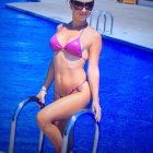 Woman in Red Bikini by Poolside on Sunny Day with Sunglasses