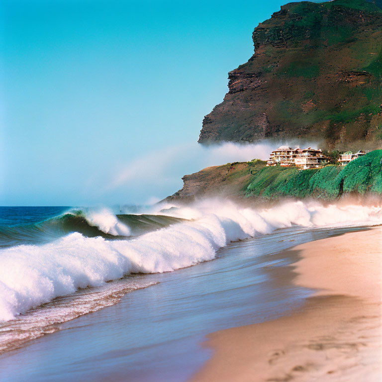 Tranquil beach scene with rolling waves, clear sky, and cliffside houses.