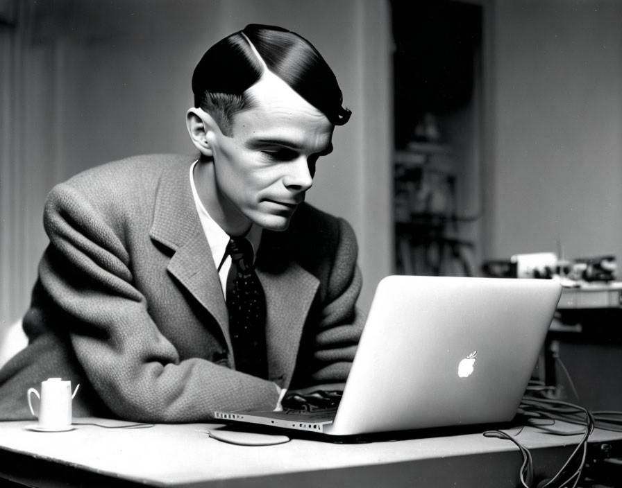 Vintage Black and White Photo: Man with Slicked Hair at Laptop with Coffee Mug