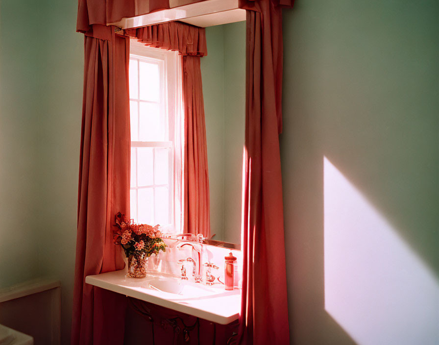 Sunlight through red curtains on vintage white desk with flowers