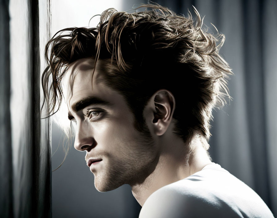 Man with Tousled Hair Gazing Out Window in Soft Light