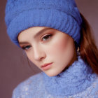 Fair-skinned person in blue knitted hat and garment, gazing at camera with subtle makeup