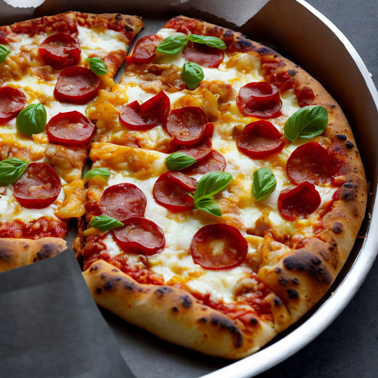 Pepperoni pizza with mozzarella, tomato sauce, and basil in cardboard box.