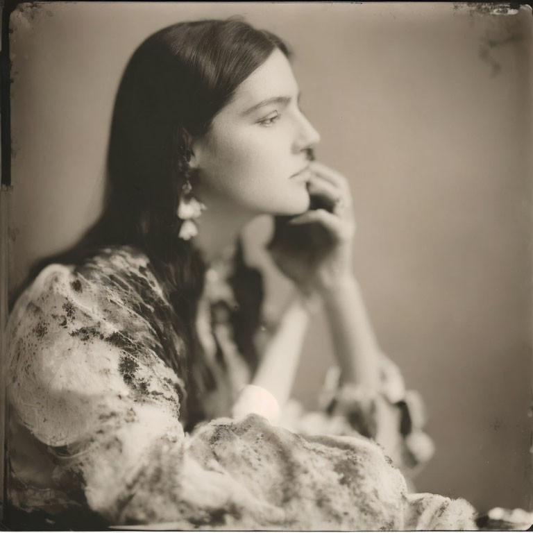 Vintage-style monochromatic portrait of woman with long earrings in profile