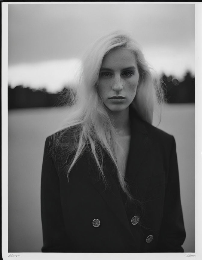 Monochrome portrait of woman with long blonde hair and dark blazer