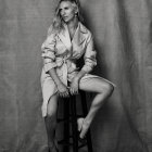 Monochrome image of woman in ballet attire on stool