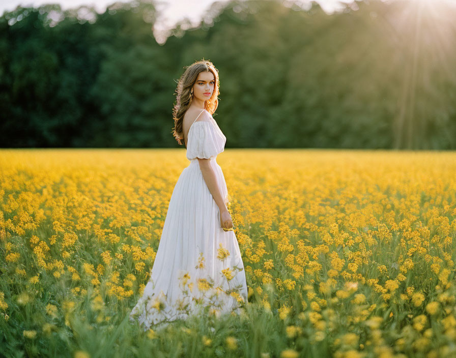 Woman in White Dress in Bright Yellow Flower Field at Sunset