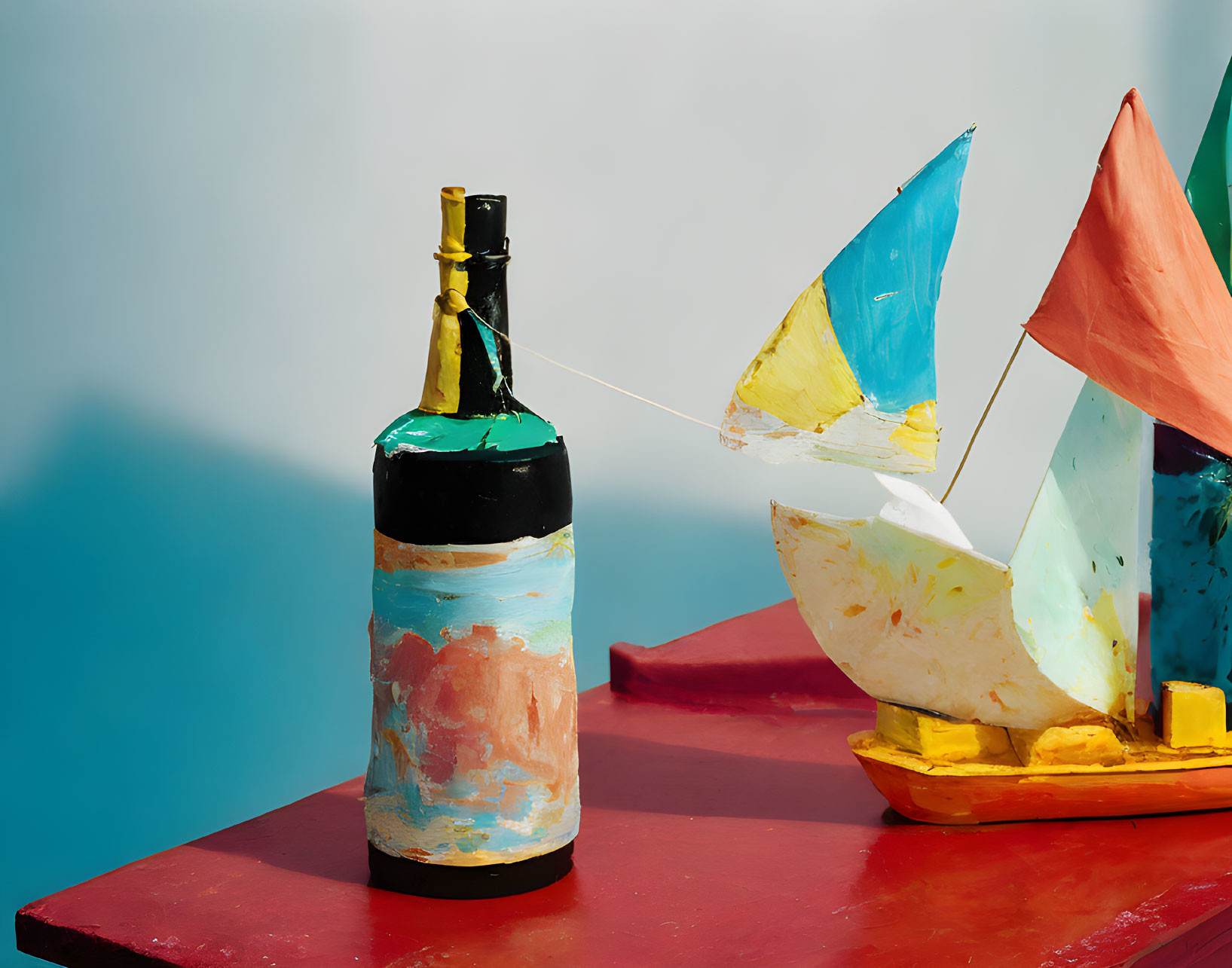 Colorful Sailboat Model Tethered to Painted Wine Bottle on Red Surface