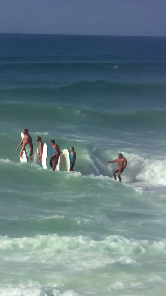 Surfers with boards riding waves in the ocean