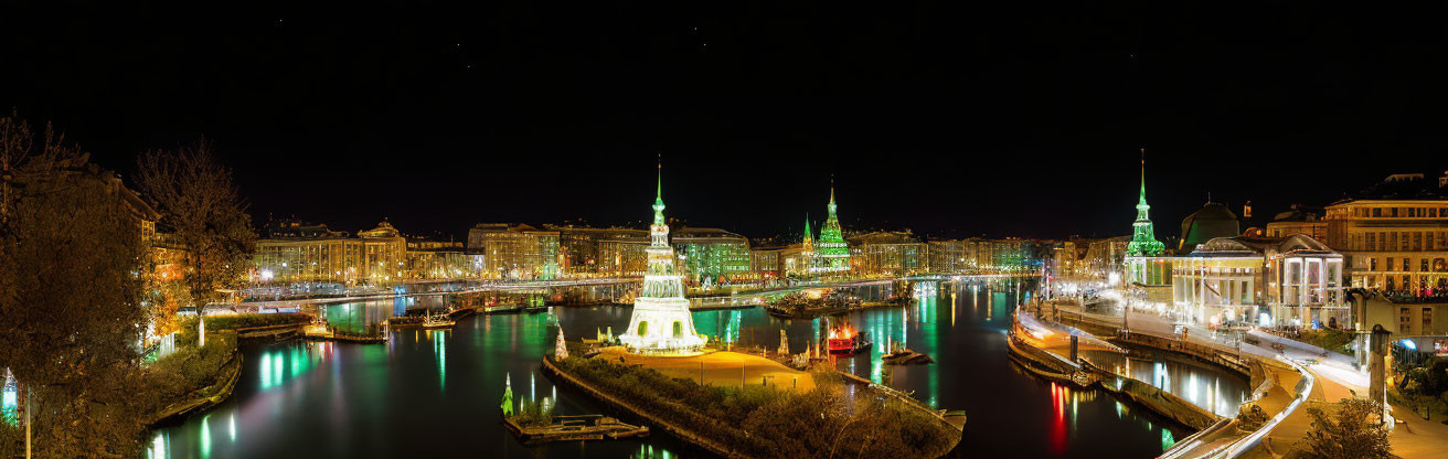 Panoramic night cityscape with illuminated buildings and river reflection