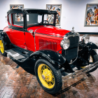 Vintage Red and Black Car with Yellow-Spoked Wheels in Foggy Setting