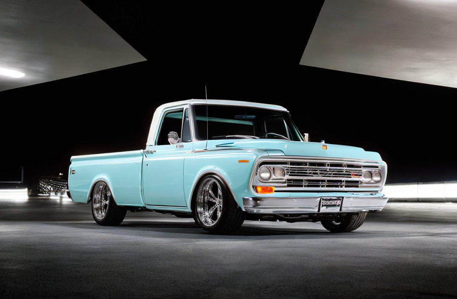 Vintage Turquoise Pickup Truck with Chrome Wheels Under Bridge at Night