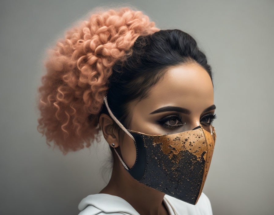 Dramatic makeup woman with gold splattered mask and curly hair