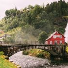 Futuristic rural landscape with traditional house, floating car, stream, and advanced structures