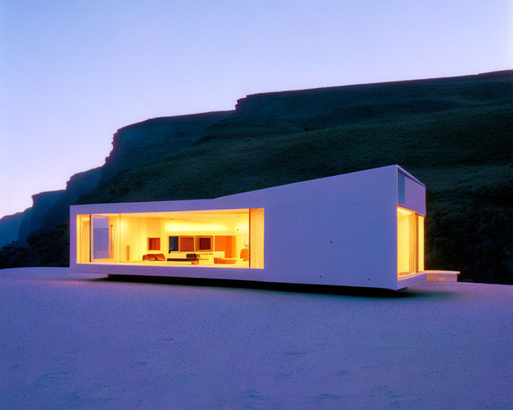 Contemporary minimalist house with large windows, glowing interior lights, twilight sky, rugged cliff.