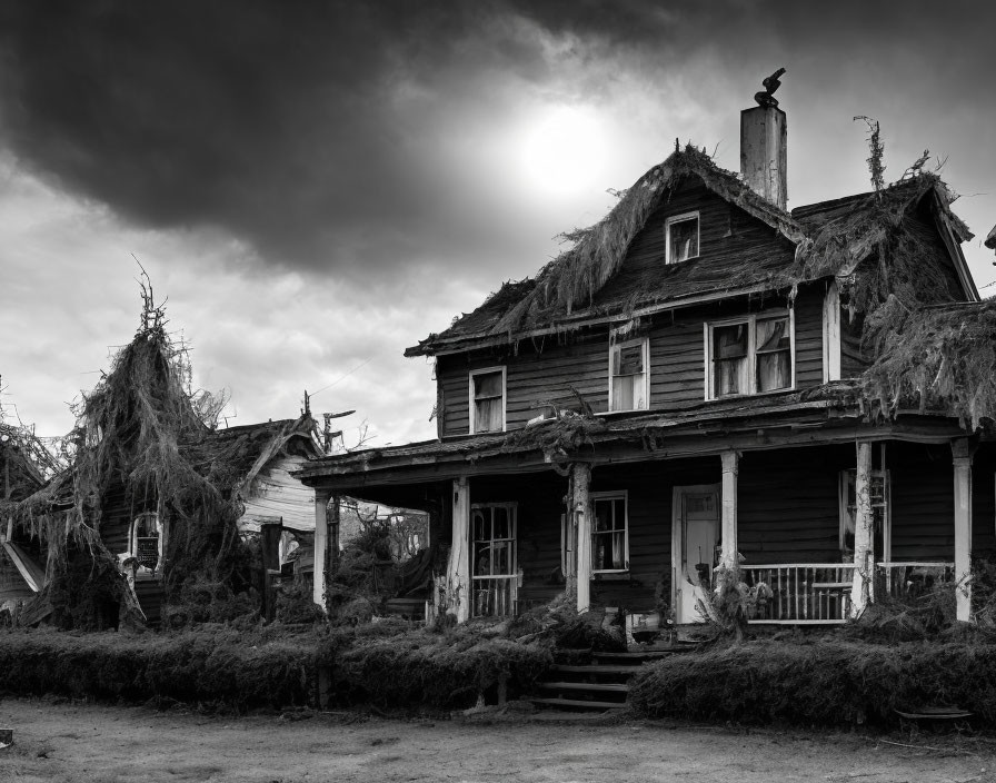 Dilapidated two-story wooden house with porch under dark sky