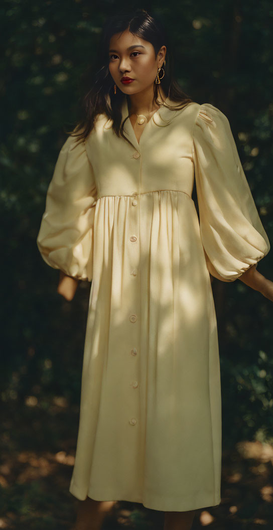 Woman in Pale Yellow Dress with Gold Accessories in Forest