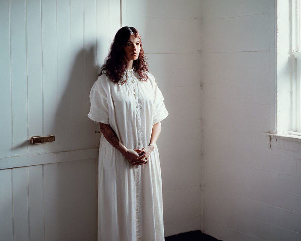 Woman in White Dress Standing in Sparse Room with Wooden Floors and Walls