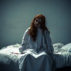 Woman in White Dress Sitting on Bed with Rumpled Sheets