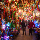 Vibrant market corridor with colorful hanging lanterns at night