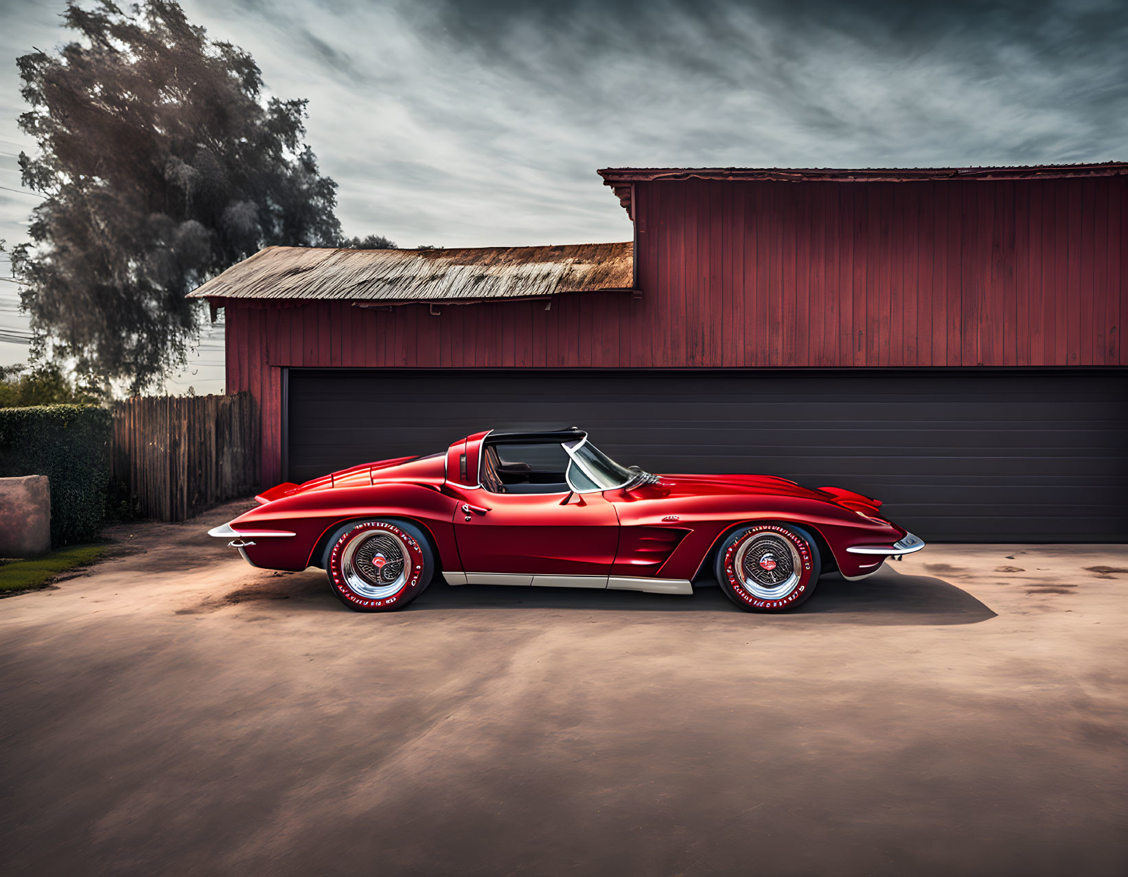 Vintage red Corvette parked next to a red barn on a sunny day