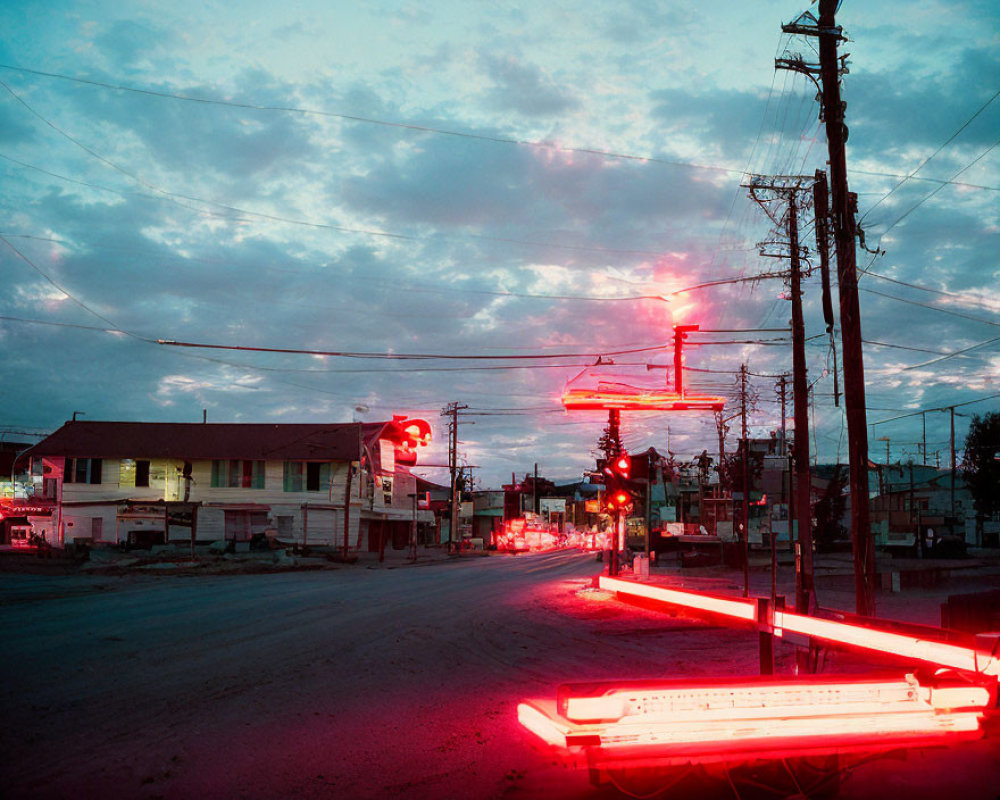 Neon-lit street at dusk with striking red glow, power lines, and cloud-streaked