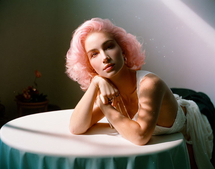 Pink-haired woman in soft sunlight with flowers in background