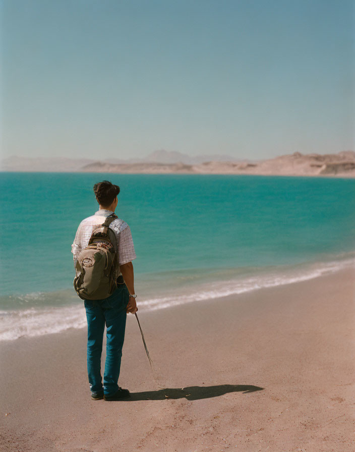 Backpacker with Walking Stick by Tranquil Blue Sea