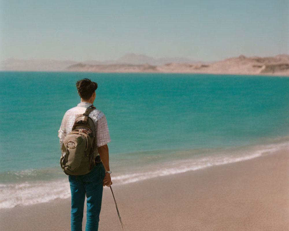 Backpacker with Walking Stick by Tranquil Blue Sea