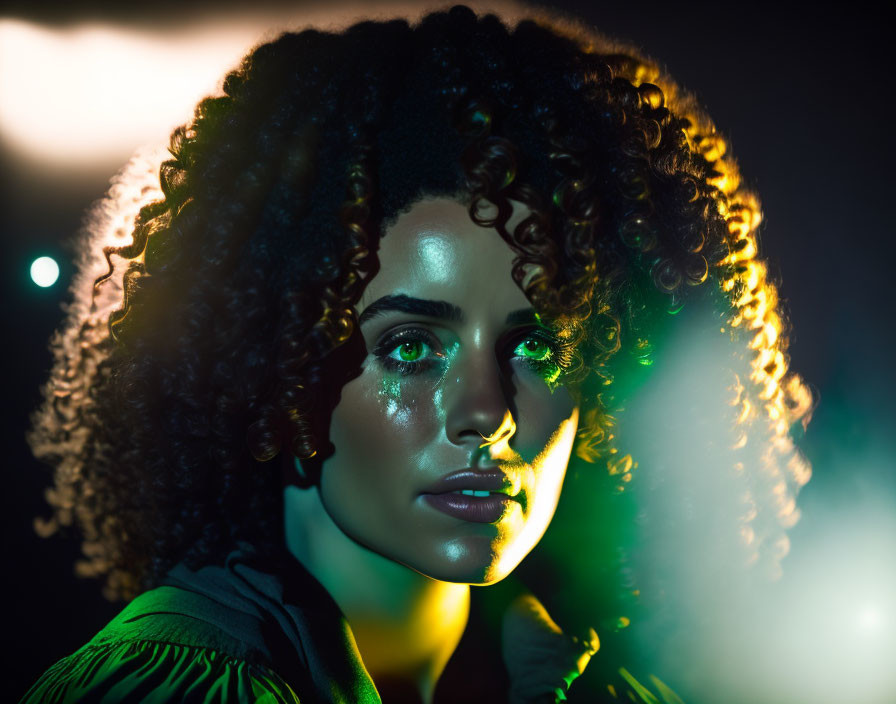 Curly-haired woman lit by green and yellow lights